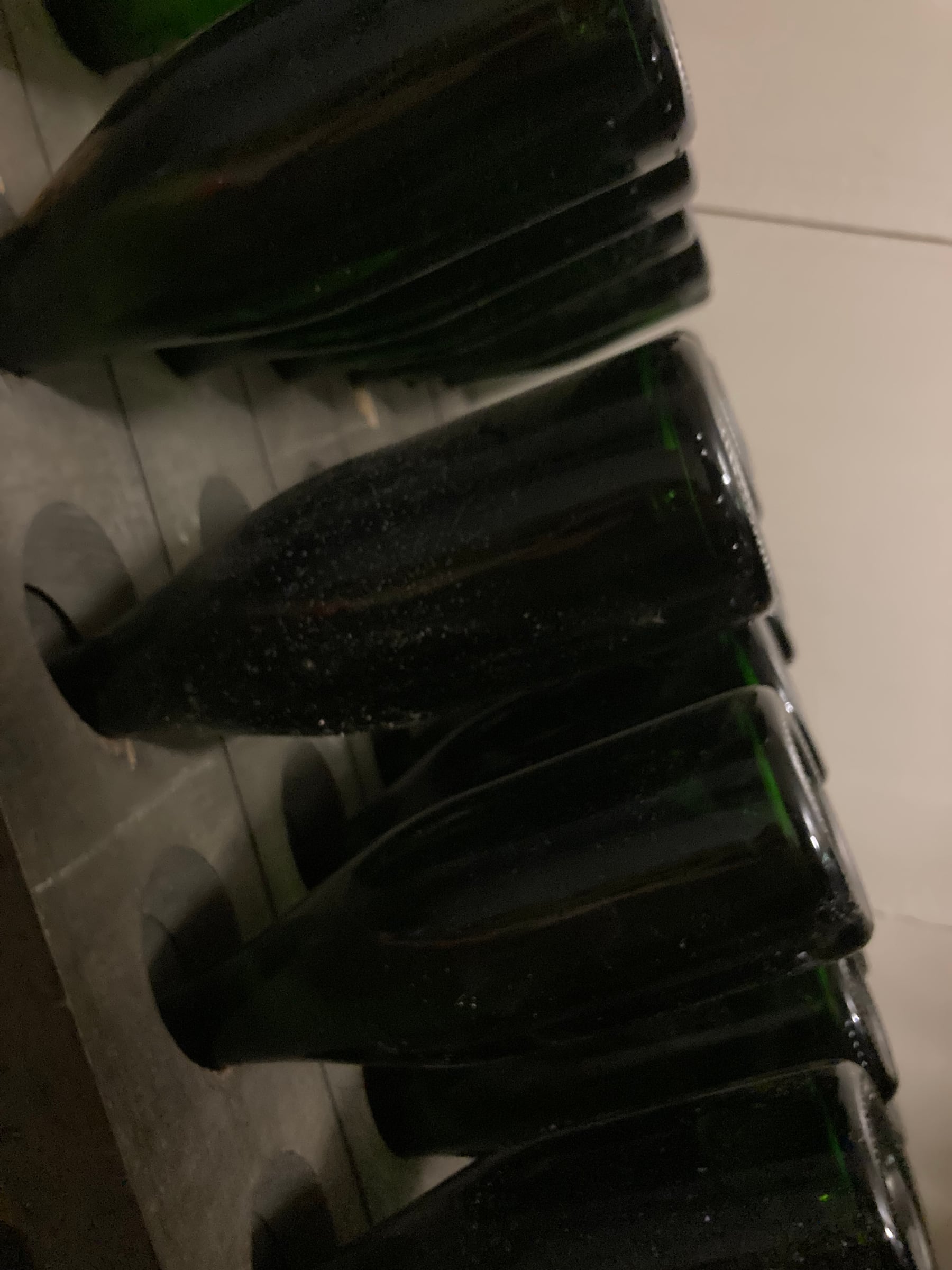 Bottiglie di Metodo Classico sulle pupitres in cantina